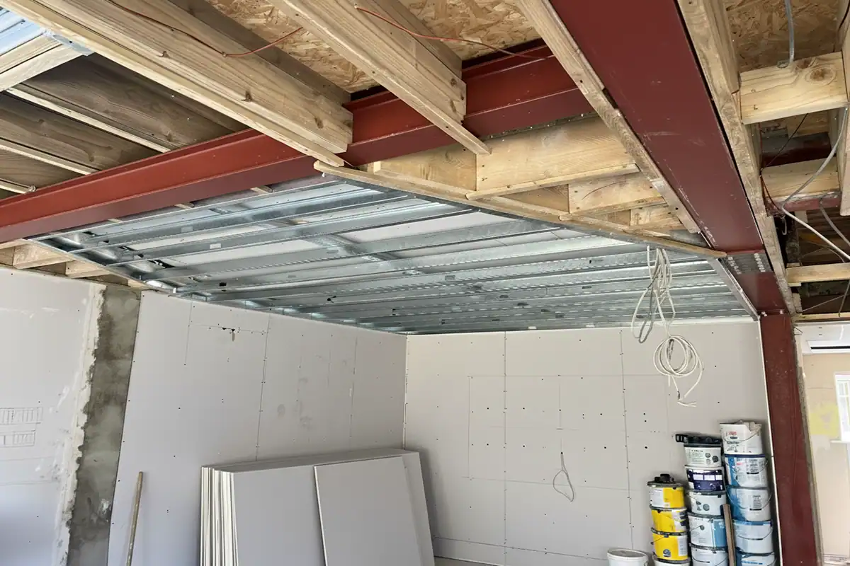 Steel RSJ beams installed after load-bearing wall removal in a London home, showing structural supports and joist connections.