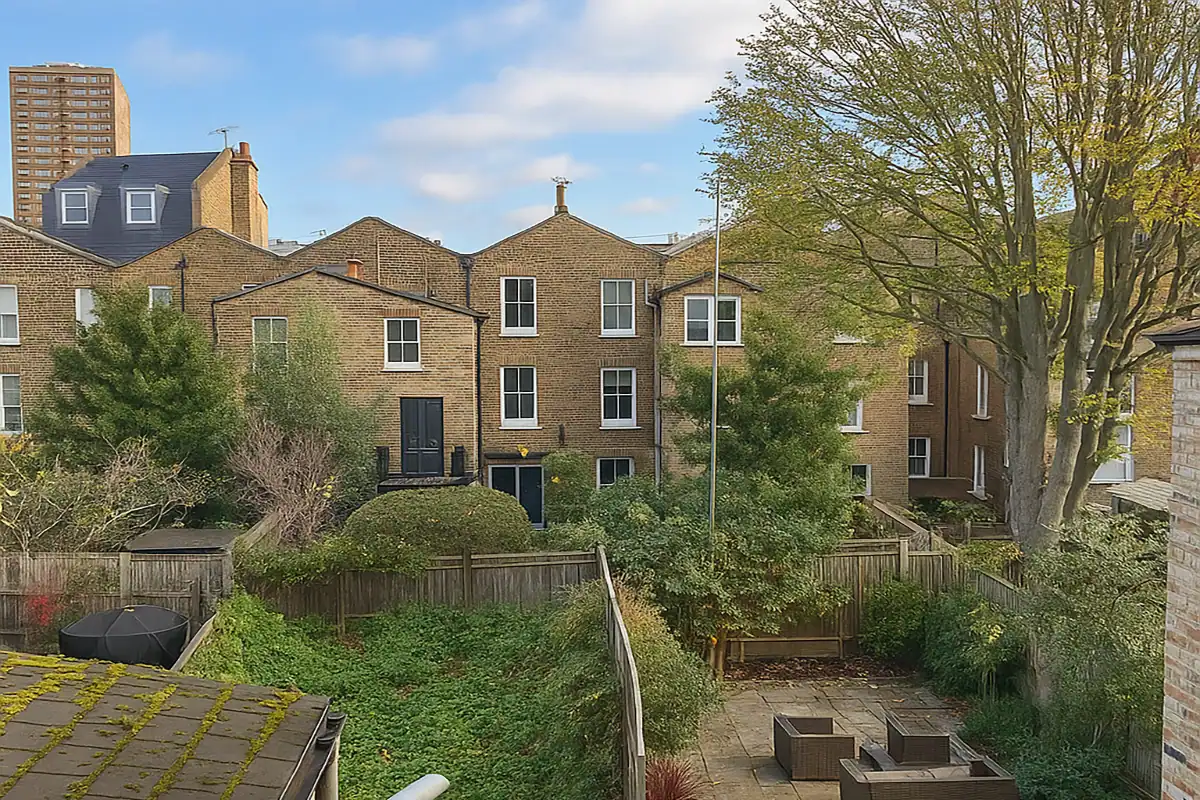 Diverse residential houses with lush garden space and mature trees in a neighbourhood setting.